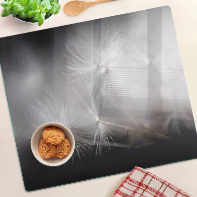 Planche à découper en verre Pissenlits duveteux sur fond de fenêtre