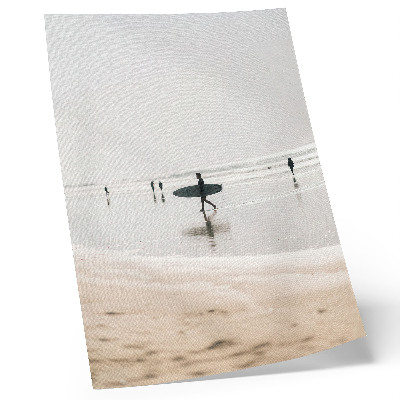 Affiche décorative Un surfeur marche sur la plage avec sa planche.