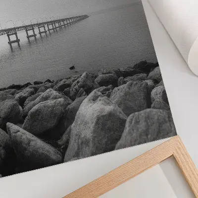 Impression sur toile paysage paisible représentant un pont sur une plage rocheuse sous un ciel gris