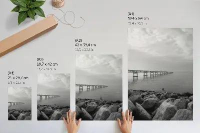 Impression sur toile paysage paisible représentant un pont sur une plage rocheuse sous un ciel gris