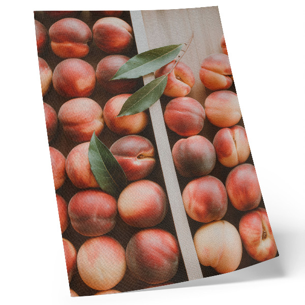 Impression sur toile Pêches avec leurs feuilles dans une boîte en bois