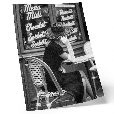 Affiche décorative Une femme portant un chapeau, assise à une table dans un café