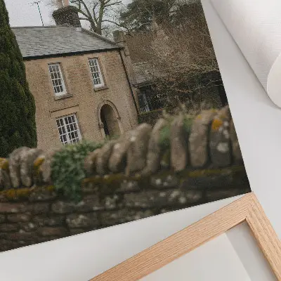 Affiche décorative représentant une maison chaleureuse, des arbres et un muret en pierre dans une atmosphère paisible