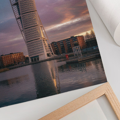 Impression sur toile Une tour moderne se détachant sur le coucher du soleil.