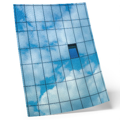 Impression sur toile Une façade de verre reflétant le ciel et les nuages