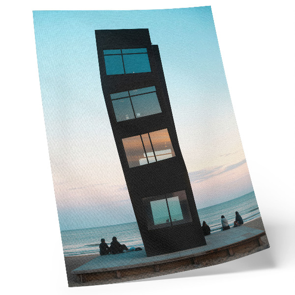 Impression sur toile Une tour noire moderne surplombant une mer bleue