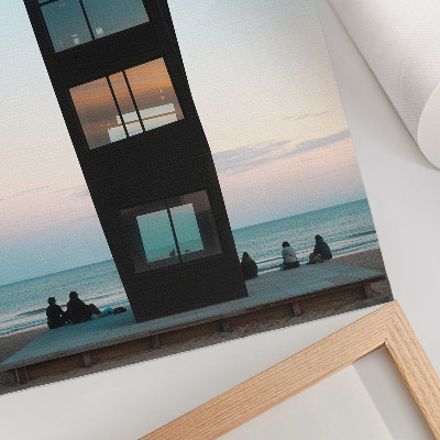 Impression sur toile Une tour noire moderne surplombant une mer bleue