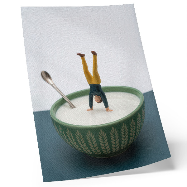 Impression sur toile Figurine dans un bol de lait avec des feuilles vertes