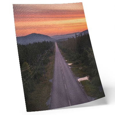 Affiche décorative Une route droite à travers la forêt au coucher du soleil aux teintes pastel