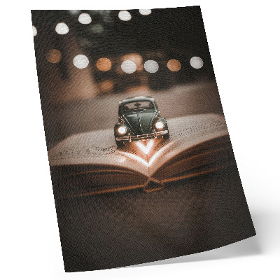 Impression sur toile Voiture miniature sur un livre avec des lumières magiques