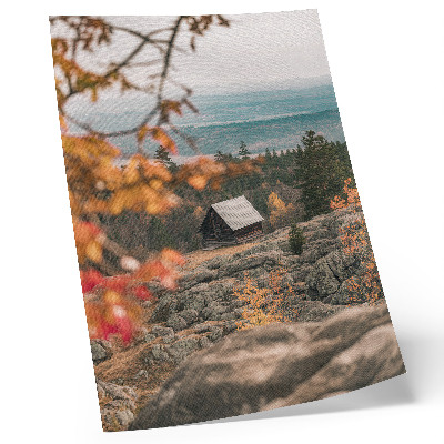 Impression sur toile Une maison sur un rocher au milieu des arbres en automne, une nature paisible