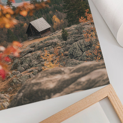 Impression sur toile Une maison sur un rocher au milieu des arbres en automne, une nature paisible