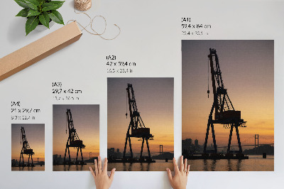 Impression sur toile Silhouette de grue industrielle au coucher du soleil sur le pont