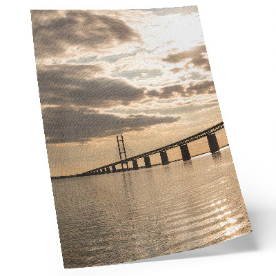 Affiche décorative Un pont au-dessus de l'eau, baigné par la lumière du soleil couchant.