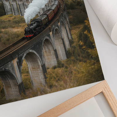 Affiche décorative Un train sur un pont au milieu de collines verdoyantes