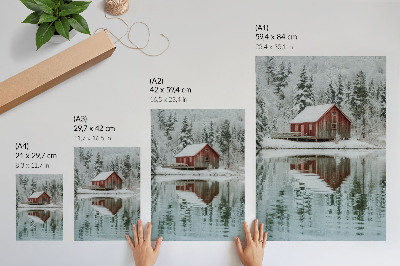Impression sur toile Un chalet rouge parmi les arbres enneigés au bord de l'eau
