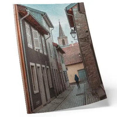 Impression sur toile rue étroite avec immeubles de rapport et tour, manteau bleu