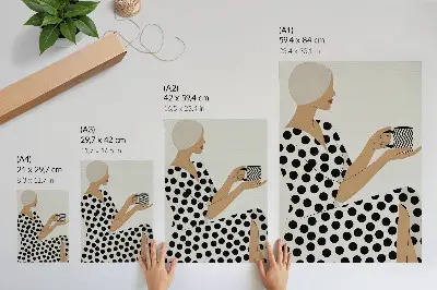 Impression sur toile représentant une femme en robe à pois tenant une tasse aux motifs géométriques