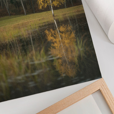 Impression sur toile Un arbre doré se détachant sur le fond d'une forêt sombre et d'un lac
