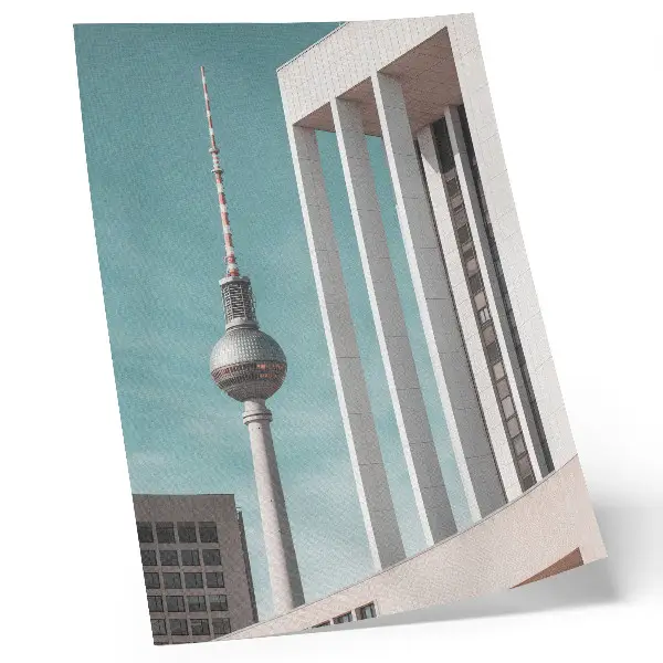 Impression sur toile représentant une tour minimaliste avec des bâtiments modernes sous un ciel bleu