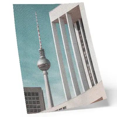 Impression sur toile représentant une tour minimaliste avec des bâtiments modernes sous un ciel bleu
