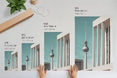 Impression sur toile représentant une tour minimaliste avec des bâtiments modernes sous un ciel bleu