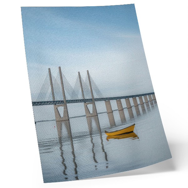 Affiche décorative Un pont se détachant sur le ciel et l'eau, avec un bateau jaune.