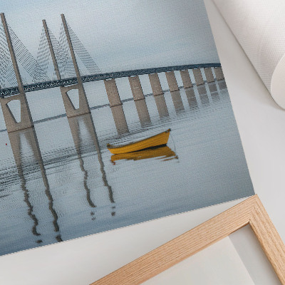 Affiche décorative Un pont se détachant sur le ciel et l'eau, avec un bateau jaune.