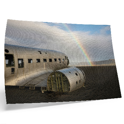 Affiche L'épave d'un avion en métal avec un arc-en-ciel en arrière-plan.