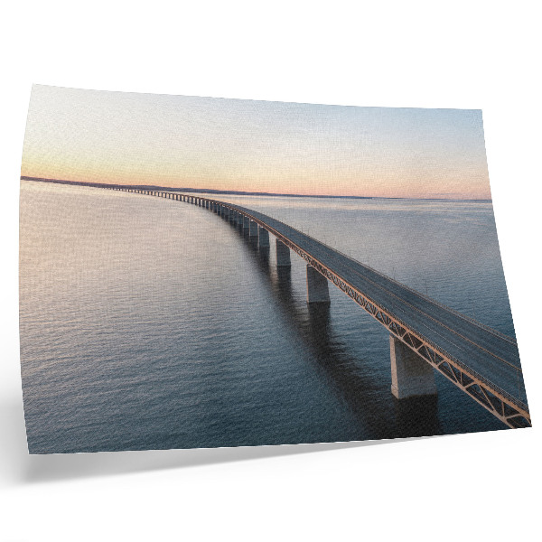 Affiche Un pont enjambant une mer calme au coucher du soleil