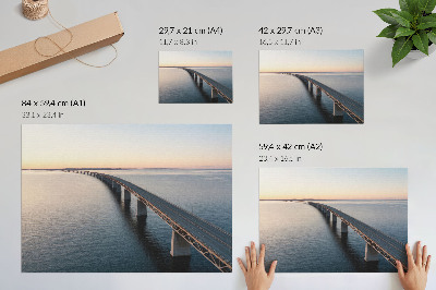 Affiche Un pont enjambant une mer calme au coucher du soleil