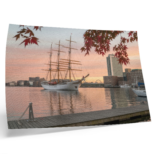 Affiche Un voilier au coucher du soleil, un panorama paisible de la ville