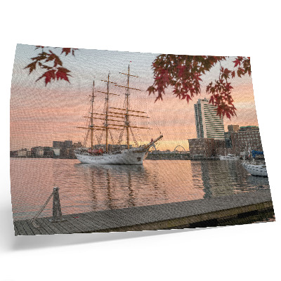 Affiche Un voilier au coucher du soleil, un panorama paisible de la ville