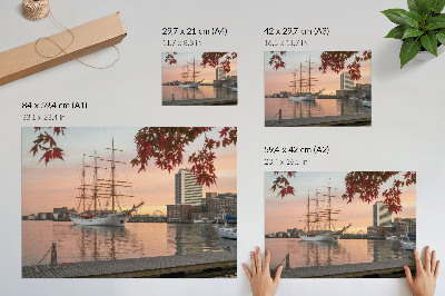 Affiche Un voilier au coucher du soleil, un panorama paisible de la ville