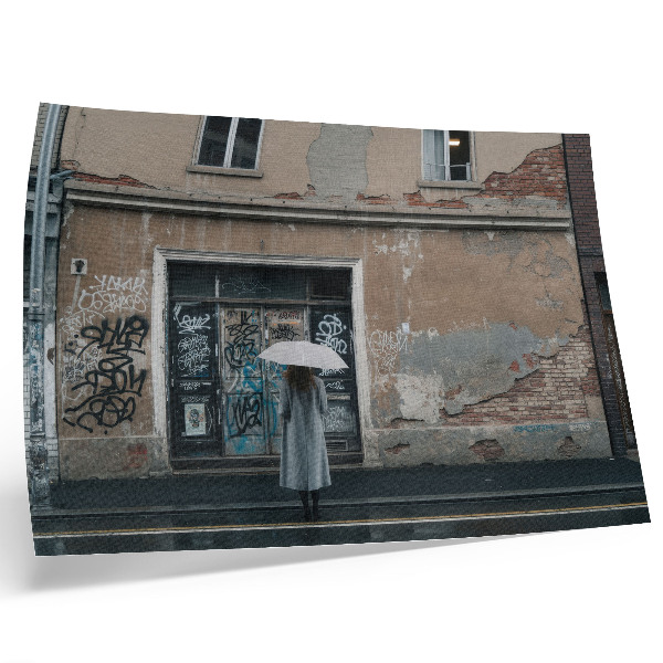 Affiche Une personne avec un parapluie devant un mur couvert de graffitis