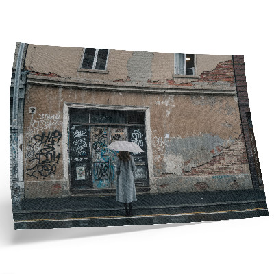 Affiche Une personne avec un parapluie devant un mur couvert de graffitis