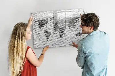 Tableau magnétique représentant une carte du monde sur un mur de briques