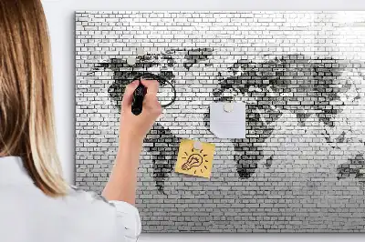 Tableau magnétique représentant une carte du monde sur un mur de briques