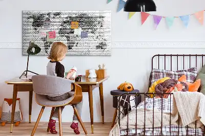 Tableau magnétique représentant une carte du monde sur un mur de briques