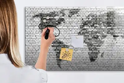 Tableau magnétique représentant une carte du monde sur un mur de briques