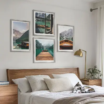 Mur de tableaux représentant des paysages de montagne avec des chalets et des bateaux