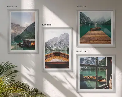 Mur de tableaux représentant des paysages de montagne avec des chalets et des bateaux