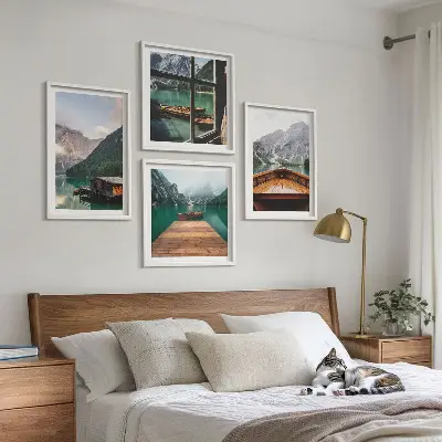 Mur de tableaux représentant des paysages de montagne avec des chalets et des bateaux
