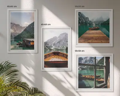 Mur de tableaux représentant des paysages de montagne avec des chalets et des bateaux