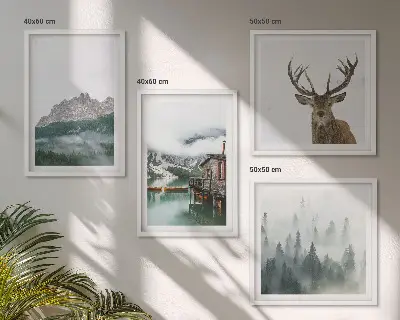 Mur de tableaux représentant des montagnes, un lac, un cerf, une cabane et du brouillard
